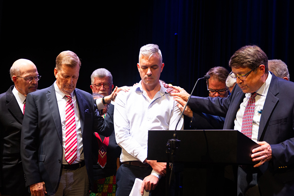 Board members pray over Andy