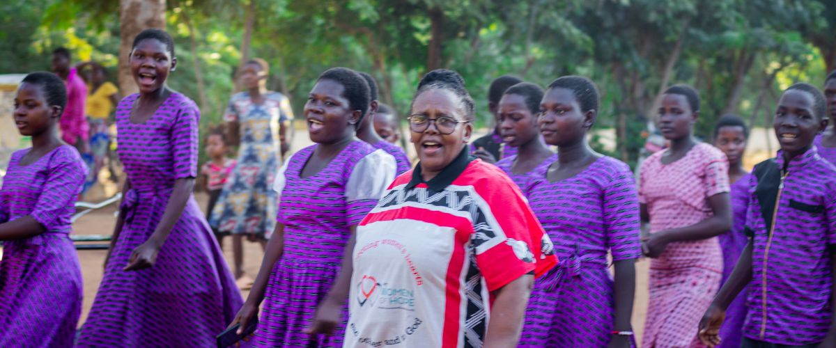 Sphiwe Ngwenya, director of Women of Hope for TWR Africa, joins a youth choir greeting us at Christian Teaching Center in the Salima District of Malawi.