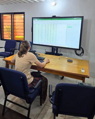 Elizabeth sits before a large monitor in the offices of the West Africa Transmitting Station. 