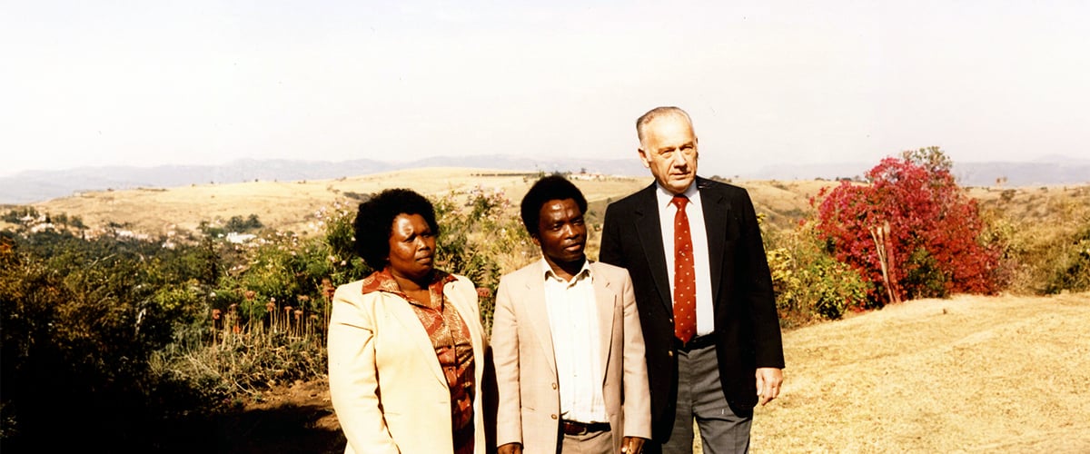 Paul Freed, Ernest Mcambi and Mrs Mcambi posing for a photo outside in Eswatini.