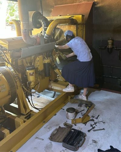 Grace helps work on one of TWR's generators on the West Africa property. 