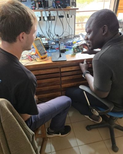 Zeke (left) spends time learning from a member of the local TWR staff in West Africa