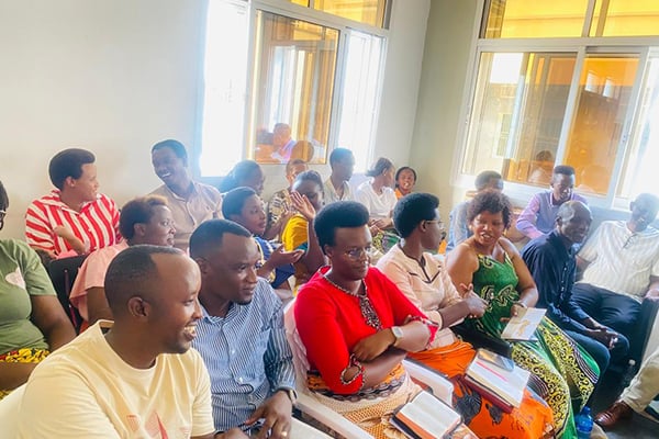 A group of African people are sitting in a room and talking to each other.