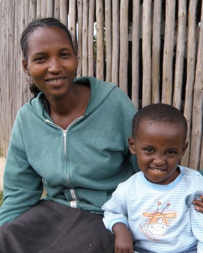 An Ethiopian woman sits with her arm around her son