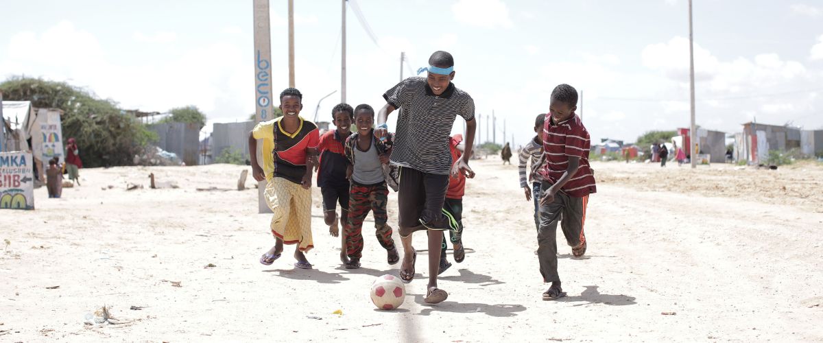 Somali youths kick a soccer ball in a Somali refugee camp