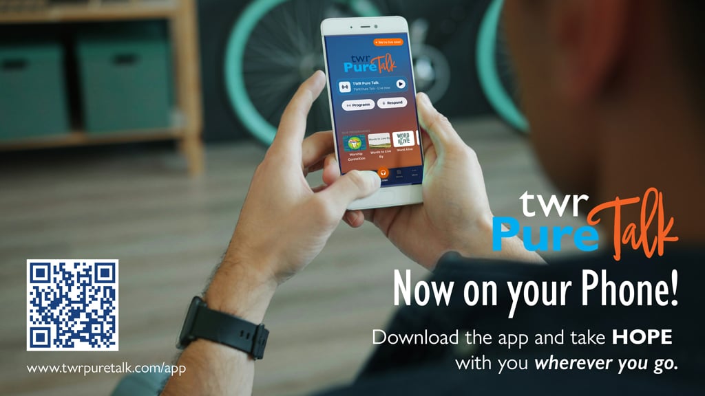 Man holding a phone with the TWR Pure Talk app showing. text on the image says, "TWR Pure Talk - Now on your phone. Download the app and take hope with you wherever you go."