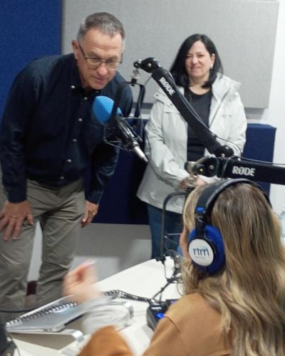 TWR Chief Content Officer Jon Fugler leans into the mic as Women of Hope Director Susie Pek looks on.