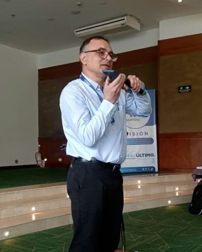 Esteban Larrosa, TWR’s vice president for Latin America and the Caribbean, holds a microphone up to his cellphone so that conference attendees could hear from Móises Pérez, director of RTM Cuba, in the wake of the destruction caused by Hurricane Melissa across the island nation.