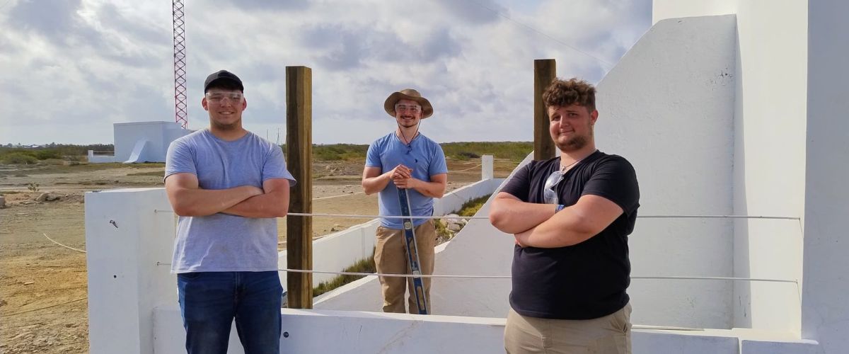 Bryson Browning (left), Burke Murray (center) and Olly Simons (right) stand next to the transmitter field on the island of Bonaire. 