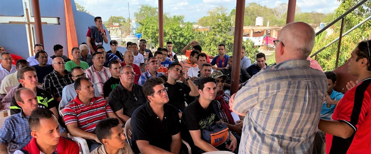 Members of the RTM Cuba team speak to a group of men in Cuba