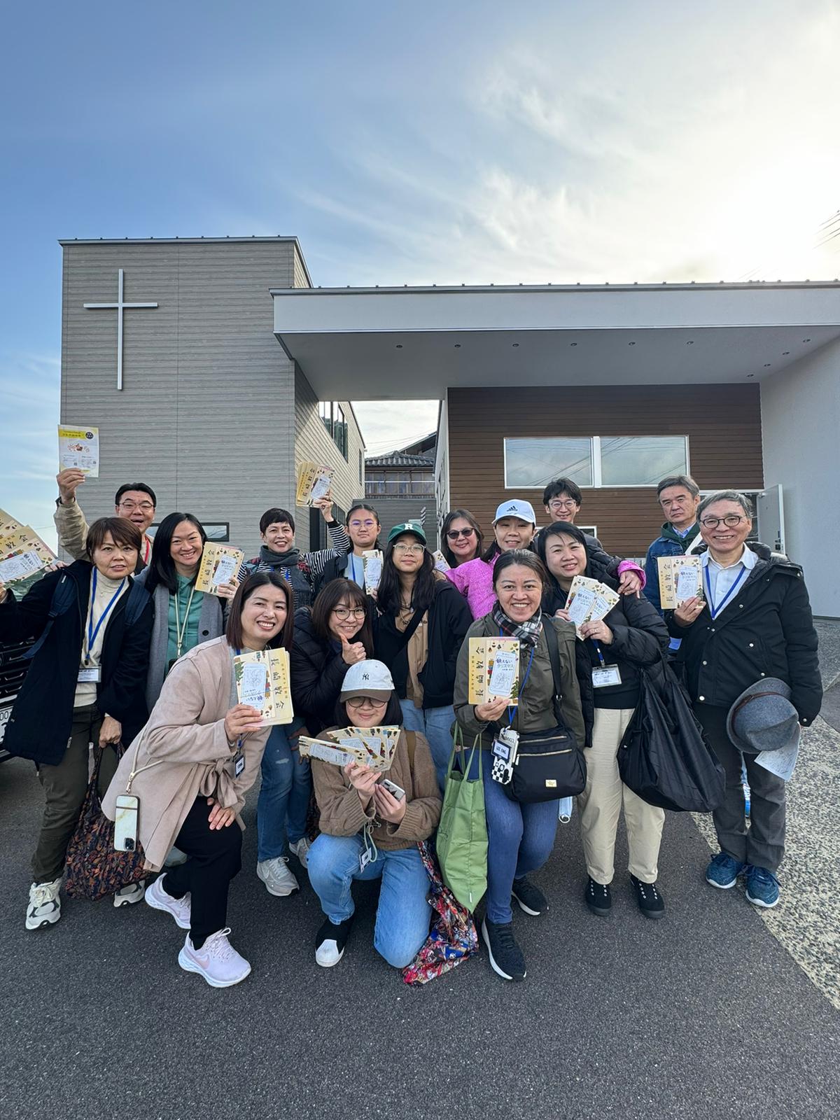 A group of DT participants gathered in front of a church with tracts in hand