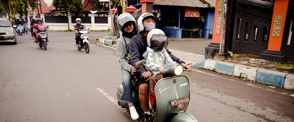 A family rides a motorcycle together in East Java, Indonesia. 
