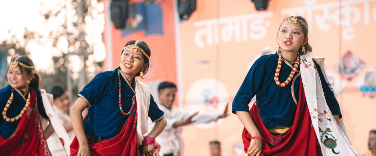 Three women dance in traditional Tamang dress
