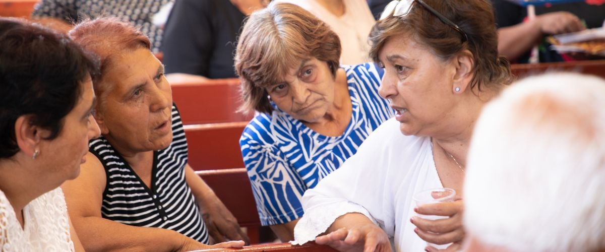 Roma women chat while sitting in the pews in their church during a TWR Women of Hope-led conference.