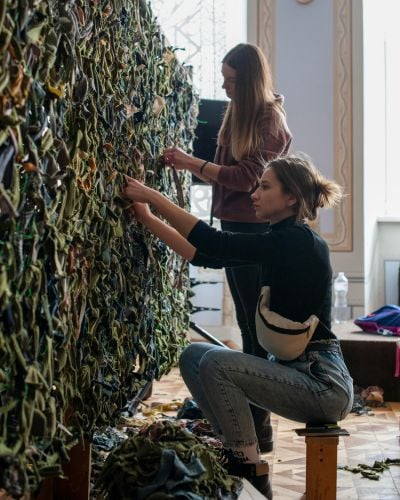Women in Ukraine weave camouflage mesh for the military.