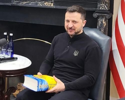 Ukrainian President Volodymyr Zelenskyy holds a Ukrainian Study Bible that Roman Kapran presented to him ahead of Zelenskyy's meeting with U.S. President Donald Trump in the White House on Feb. 28, 2025. 