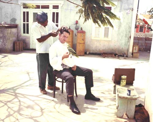 Tom Lowell receiving a haircut at a local backyard barbershop on Bonaire in 1966