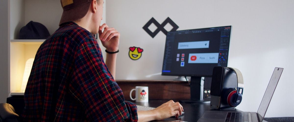 A graphic designer looks at his wotk on a computer screen