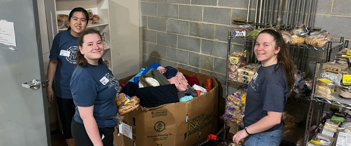 Abi (right) and her fellow TWR summer interns, Kristina (center) and Elizabeth (left) give back to the community by volunteering at a local resource center. 