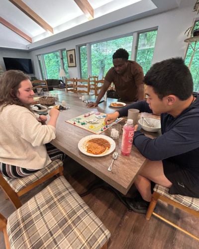 Luswepo and fellow summer interns, Kristina and Elliott, play a board game in TWR's Lodge guesthouse.