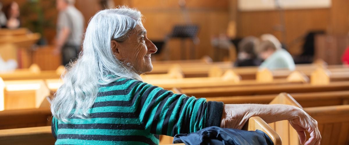 An elderly woman sits in the pews during a TWR Women of Hope-led conference at a church in Bulgaria
