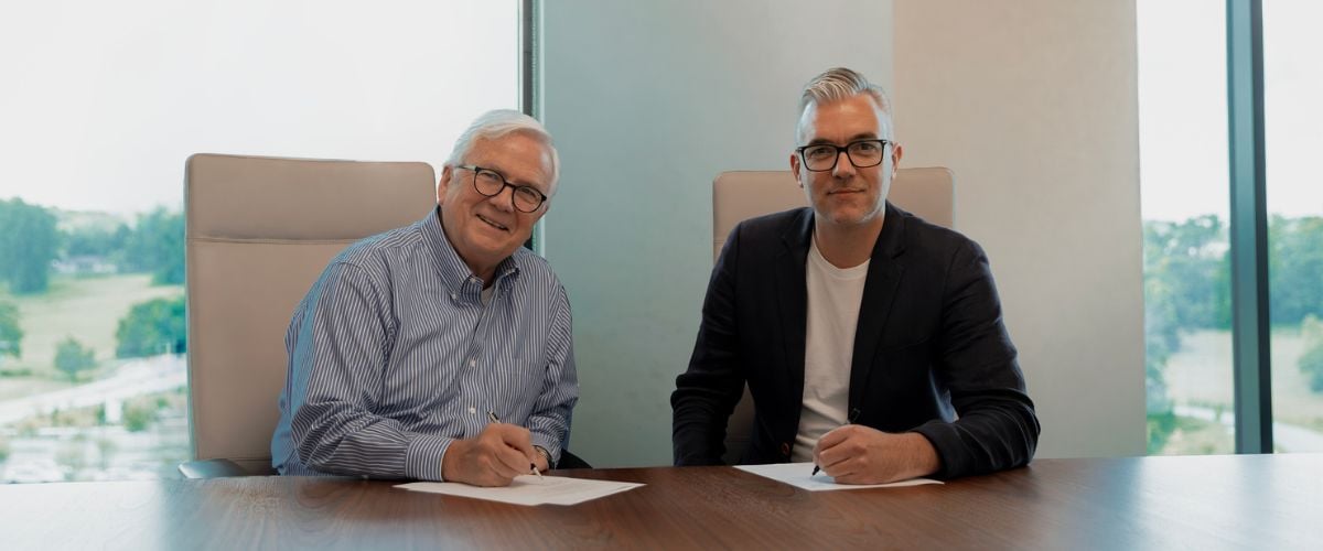TWR President Andy Schick and K-LOVE CEO Tom Stultz sign documents, officially marking the beginning the TWR and K-LOVE partnership.