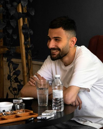 A young Iranian man laughs at a table in a cafe in Iran