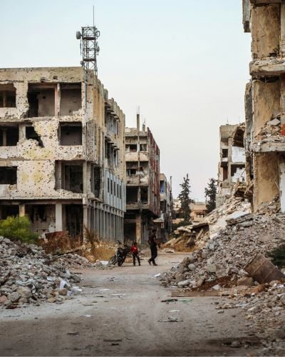Two people are seen navigating the wartorn streets of Daraa, Syria.
