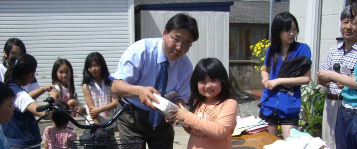 Pastor Park hands a gift to a girl